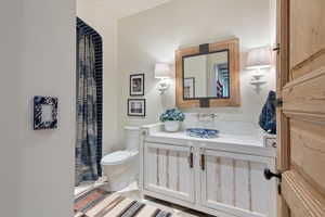 Bathroom featuring toilet, walk in shower, vanity, and tile patterned flooring