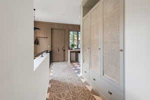 Hallway featuring wooden walls