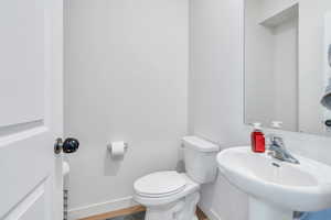 Bathroom with hardwood / wood-style flooring, sink, and toilet