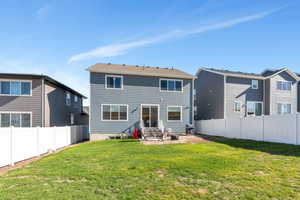 Rear view of property featuring a lawn and a patio