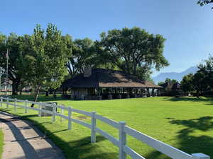 View of home's community featuring fence, a mountain view, and a lawn