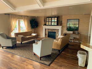 Living area featuring beam ceiling, a fireplace, visible vents, and dark wood-style flooring