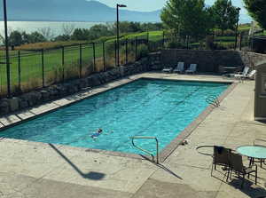 View of pool with a fenced in pool, a mountain view, fence, and a patio