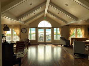 Interior space featuring french doors, a healthy amount of sunlight, dark wood finished floors, and lofted ceiling with beams