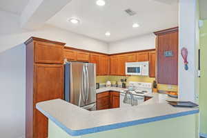 Kitchen featuring kitchen peninsula and white appliances