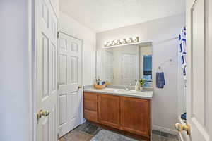 Bathroom with vanity and a textured ceiling