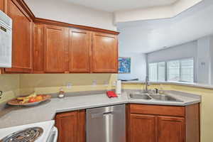 Kitchen featuring white appliances, sink, and kitchen peninsula