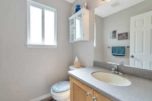 Bathroom with plenty of natural light, vanity, and toilet