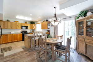 Dining area featuring a textured ceiling, an inviting chandelier, and light hardwood / wood-style flooring