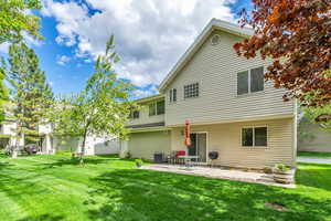 Back of property featuring cooling unit, a patio, and a yard