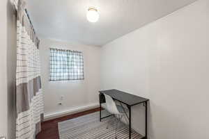 2nd bedroom or home office with dark wood-type flooring and a textured ceiling