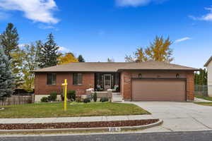 Ranch-style home with a front yard and a garage