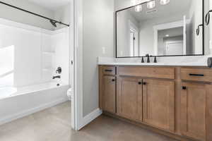 Full bathroom with tile patterned flooring, vanity, toilet, and washtub / shower combination