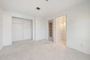 Unfurnished bedroom featuring light tile patterned floors and a closet