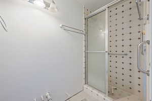 Bathroom featuring tile patterned floors and a shower with shower door