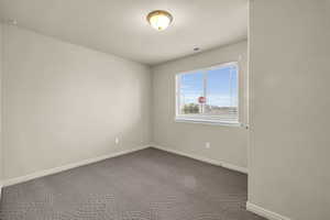 Spare room featuring a textured ceiling and carpet flooring