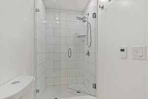 Large tiled shower with infinity glass enclosure, and a skylight.