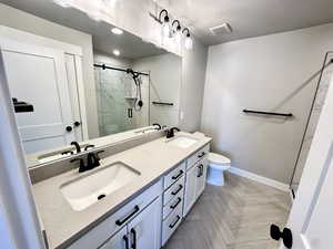 Bathroom with vanity, toilet, an enclosed shower, and a textured ceiling