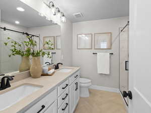 Bathroom featuring parquet flooring, vanity, toilet, and an enclosed shower