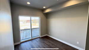 Spare room featuring dark wood-type flooring