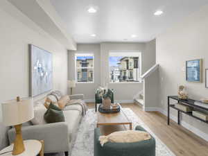 Living room with a textured ceiling and light hardwood / wood-style flooring