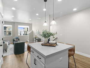 Kitchen featuring a breakfast bar area, a center island, pendant lighting, and light wood-type flooring