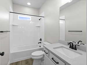 Full bathroom with vanity, toilet, wood-type flooring, and tub / shower combination