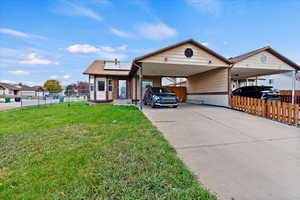 View of front of house with a front lawn and a carport