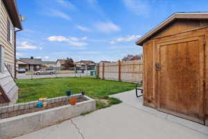 View of yard with a storage unit and a patio