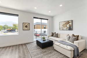 Living room with a textured ceiling, hardwood / wood-style floors, a mountain view, and a healthy amount of sunlight