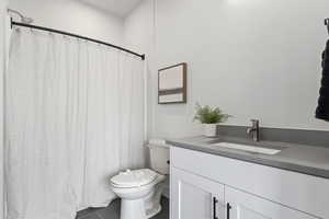 Bathroom featuring toilet, vanity, and tile patterned flooring