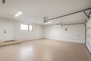 Garage with a garage door opener and a wall mounted AC