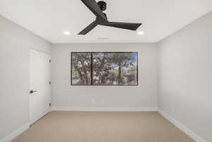 Carpeted empty room featuring ceiling fan