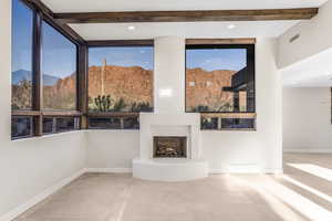 Unfurnished living room featuring beamed ceiling, tile patterned flooring, and a mountain view