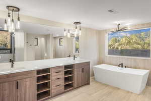 Bathroom featuring a tub, vanity, hardwood / wood-style flooring, and a chandelier