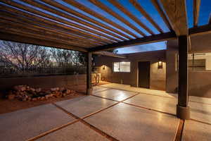 Patio terrace at dusk featuring a pergola