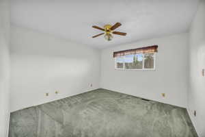 Carpeted spare room with ceiling fan