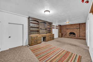 Living room with a textured ceiling, light carpet, and a fireplace