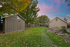 Yard at dusk featuring a storage unit