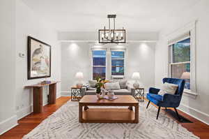 Living room featuring dark wood-type flooring and a chandelier