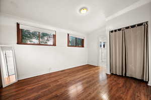 Unfurnished bedroom with dark wood-type flooring