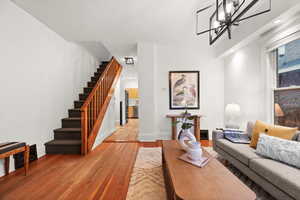 Living room featuring light wood-type flooring and a notable chandelier