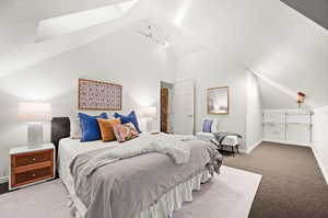 Carpeted bedroom featuring vaulted ceiling