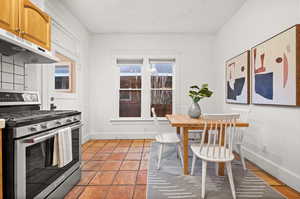 Kitchen featuring high end stainless steel range oven and light tile patterned flooring