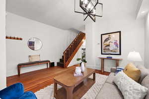 Living room featuring wood-type flooring and a notable chandelier