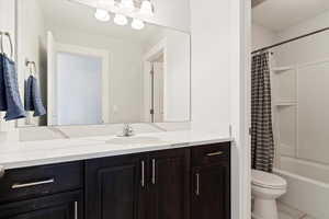 Full bathroom featuring shower / bath combo, tile patterned flooring, vanity, and toilet