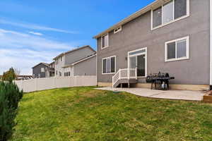 Rear view of property with a patio and a yard