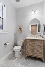 Half Bathroom featuring toilet, vanity, and tile patterned floors