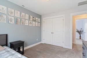 Carpeted bedroom with a closet