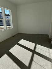 Unfurnished room featuring dark colored carpet